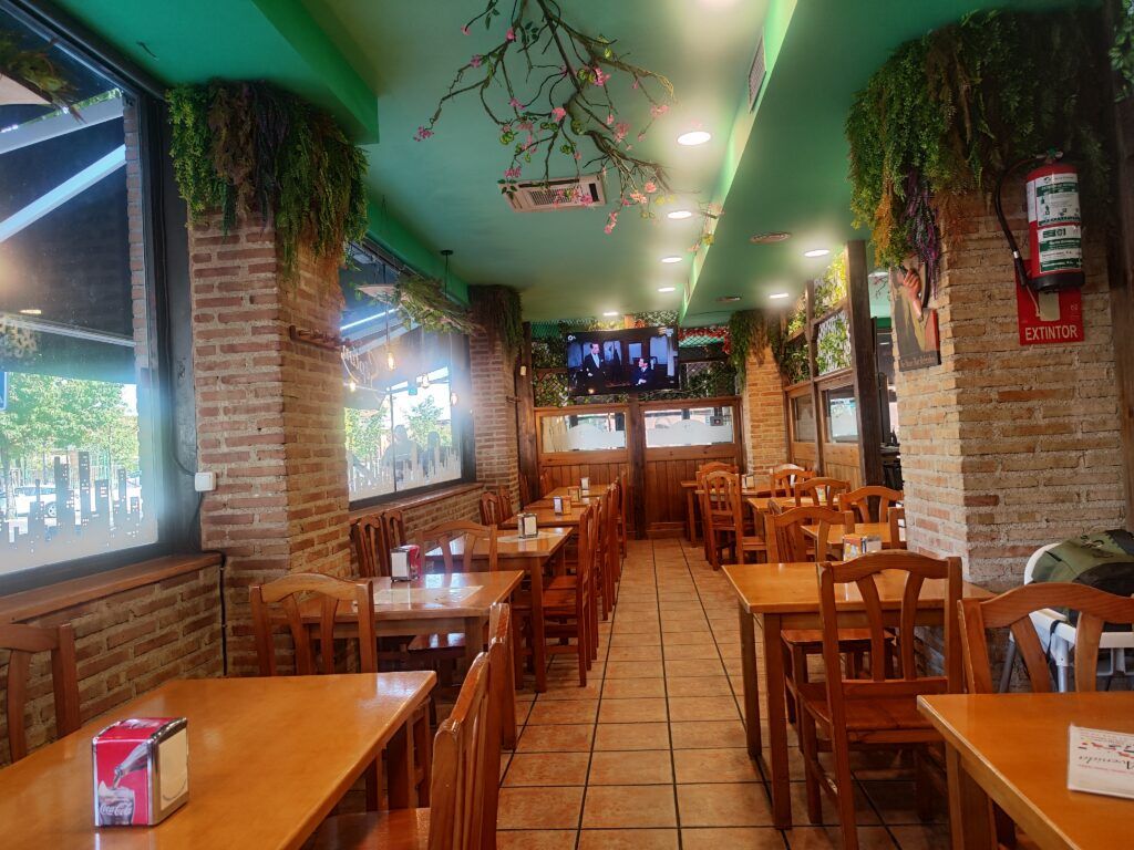 salón con mesas y sillas de restaurante septima avenida en mostoles